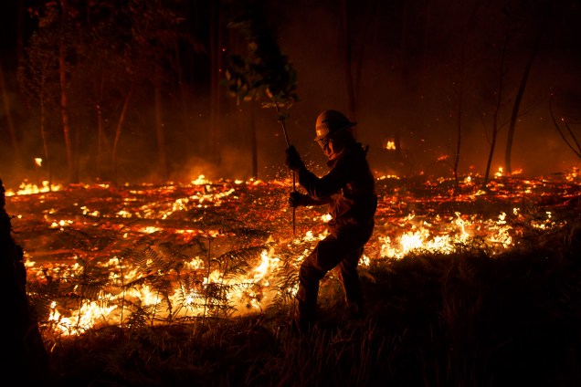 Bombeiro da Guarda Nacional Republicana tenta controlar um incêndio em uma floresta em Pedrógão Grande, no distrito de Leiria, em Portugal. Incêndios na região central do país deixaram ao menos 64 mortos - 19/06/2017