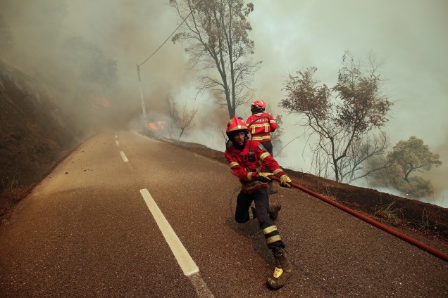 Bombeiros trabalham para apagar um incêndio florestal na aldeia de Sandinha, perto de Góis, em Portugal - 20/06/2017