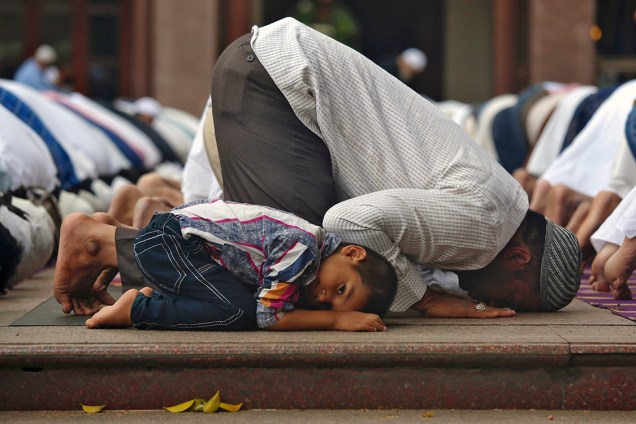 Jovem muçulmano acompanha familiares durante orações em uma mesquita na cidade de Bengaluru, na Índia - 16/06/2017