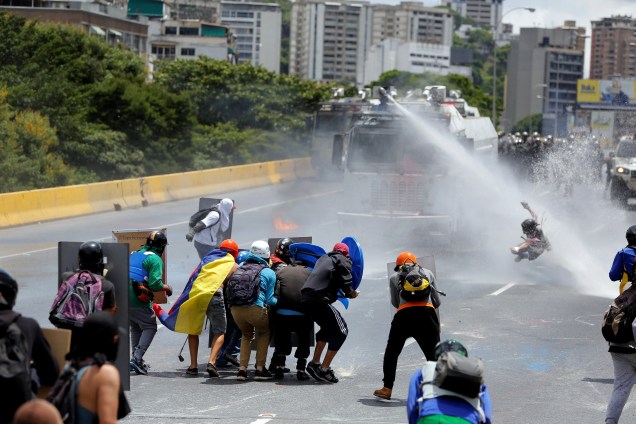 Manifestante é atingido por jato d'água das forças de segurança venezuelanas durante protesto contra o atual governo do presidente Nicolas Maduro, em Caracas - 20/06/2017