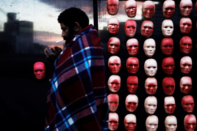 Morador de rua atravessa uma instalação com máscaras que representam os rostos dos políticos durante protesto da organização Rio de Paz contra os escândalos de corrupção política na Avenida Paulista em São Paulo - 01/06/2017