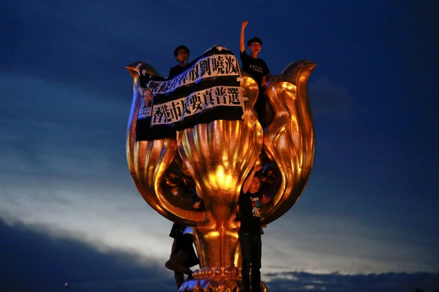 Manifestantes pró-democracia escalam o monumento simbólico de  Golden Bauhinia dado pela China em 1997 em protesto antes da visita do presidente chinês Xi Jinping em Hong Kong - 28/06/2017