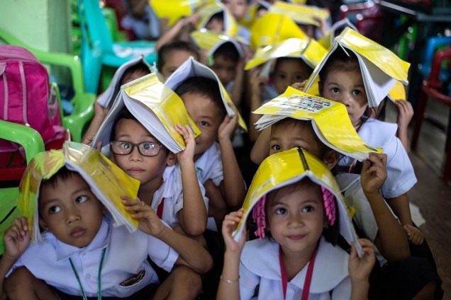 Crianças da Escola Primária Corazon Aquino participam de um treinamento   de terremoto em Manila, nas Filipinas - 29/06/2017