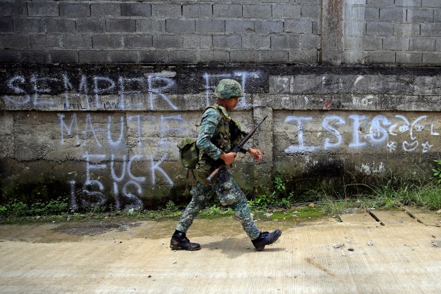 Soldado passa por um grafite durante ofensiva de tropas governamentais contra insurgentes do grupo extremista islâmico Maute, que assumiram grandes partes da cidade de Marawi, nas Filipinas - 02/06/2017