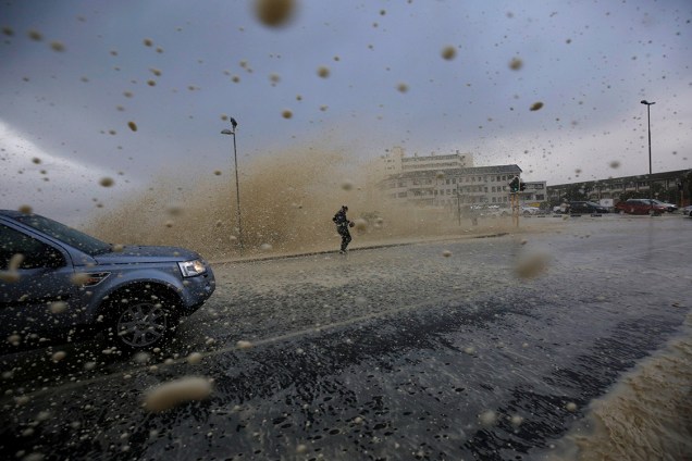 Homem corre para se proteger durante tempestade na Cidade do Cabo, África do Sul - 07/06/2017