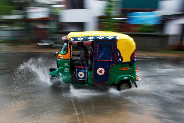Condutor dirige um tuk tuk durante uma forte chuva em Agartala, na Índia - 01/06/2017
