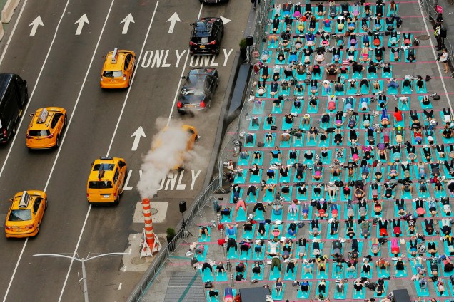 Pessoas participam de uma aula de ioga durante um evento anual do Solstício no distrito Times Square em Nova York, nos Estados Unidos - 21/06/2017