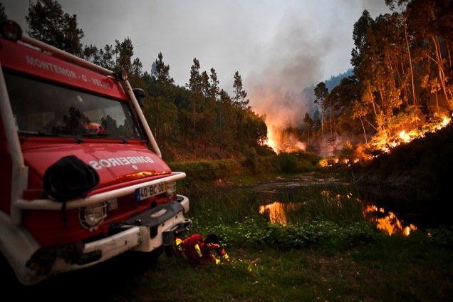 Bombeiros descansam após tentativa de apagar incêndio que atingiu uma floresta próxima a Penela, em Coimbra, deixando pelo menos 62 mortos - 18/06/2017