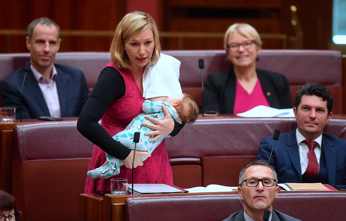 Senadora australiana Larissa Water amamenta sua filha durante sessão no parlamento em Canberra, Austrália