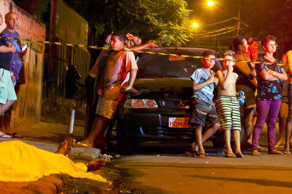 INDIFERENÇA – Crianças observam com naturalidade o corpo fuzilado em uma rua de Realengo: tão comum é a cena de cadáveres por recolher que as pessoas vão estabelecendo uma macabra convivência com a morte