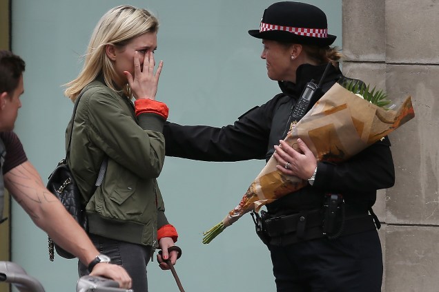 Mulher chora ao levar flores ao local do atentado na London Bridge - 04/06/2017
