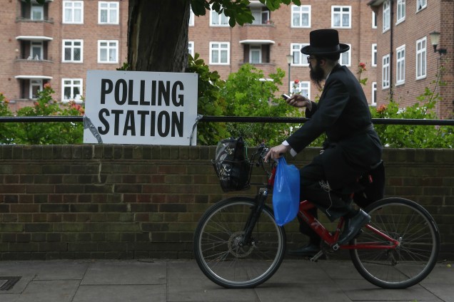 Judeu ortodoxo chegando no local da votação das eleições gerais inglesas em sua bicicleta.
