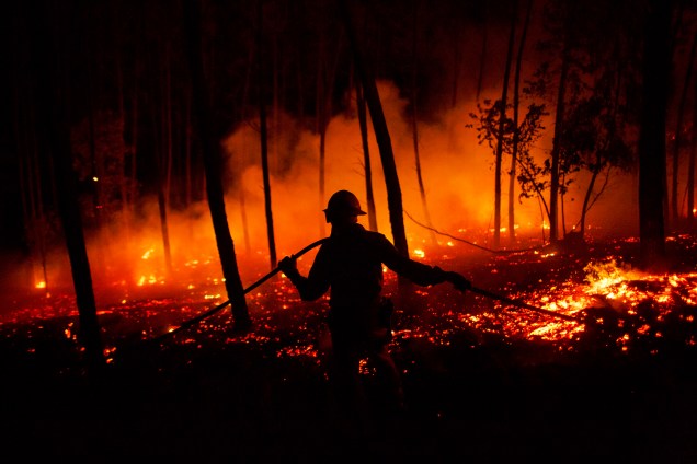 Bombeiro da Guarda Nacional Republicana  trabalha na tentativa de extinguir um incêndio  florestal nos arredores de Pedrógão Grande, no distrito de Leiria, em Portugal - 19/06/2017