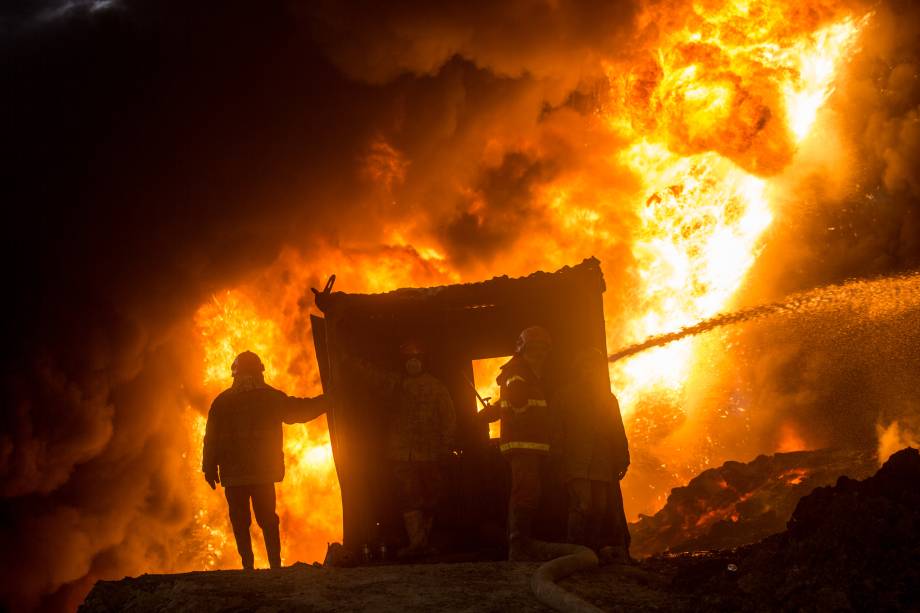 Bombeiros trabalham para apagar fogo causado por ofensiva do exército iraquiano, com objetivo de retomar a cidade de Mosul, antes ocupada pelo Estado Islâmico