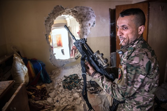 Soldado do exército iraquiano ajusta seu rifle durante ofensiva na cidade de Mosul, no Iraque