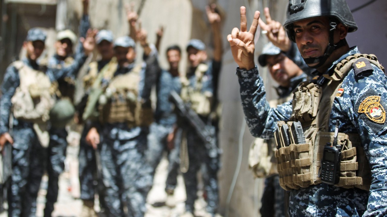 Membros da policia federal iraquiana comemoram a vitória da retomada da velha cidade de Mosul, antes ocupada pelo Estado Islâmico