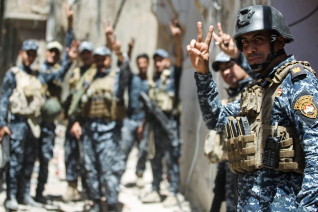Membros da policia federal iraquiana comemoram a vitória da retomada da velha cidade de Mosul, antes ocupada pelo Estado Islâmico