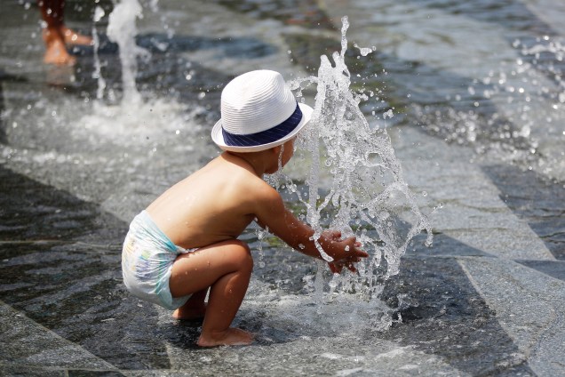 Uma criança aproveita as água do Miroir d'Eau, em Nantes, para se refrescar durante o verão francês - 20/06/2017