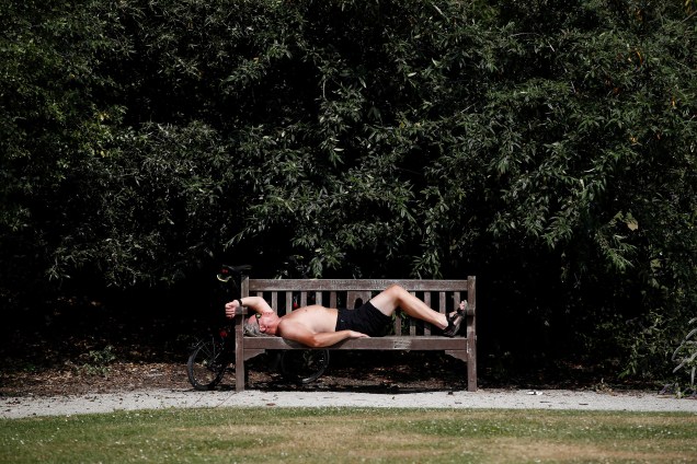Homem deitado em um banco de um parque de Londres descansa sob o sol durante as altas temperaturas do verão europeu - 21/06/2017