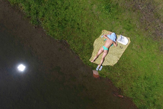 Mulher toma o sol às margens do rio Yenisei em um dia quente de verão em Krasnoyarsk, na Rússia - 22/06/2017