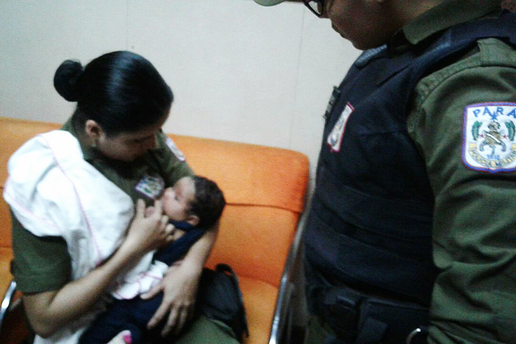 Policial militar amamentando um bebê