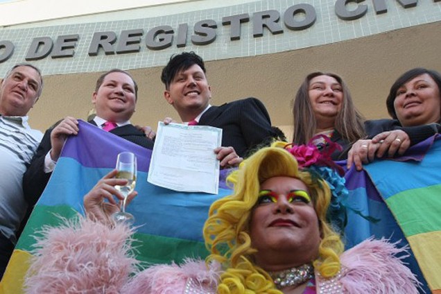 O comerciante Luiz André, de 37 anos, e o cabeleireiro José Sérgio, de 29 anos, ambos de terno preto, são o primeiro casal gay a obter a certidão de casamento civil no Brasil