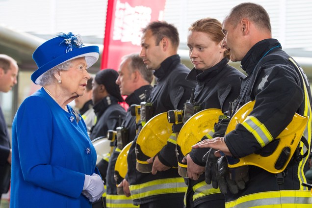 Rainha Elizabeth II conversa com bombeiros durante visita ao centro de atendimento às vítimas do incêndio em Londres, Inglaterra - 16/06/2017