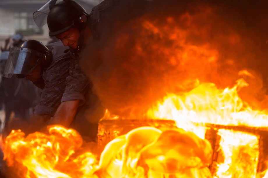 Policiais tentam apagar barricada em chamas feita por manifestantes durante protesto contra as reformas econômicas propostas pelo presidente Michel Temer em São Paulo.