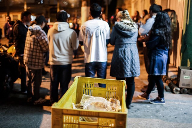 Voluntário rezam em uma rua do Cambuci, zona central de São Paulo, antes de distribuirem sopas para moradores de rua