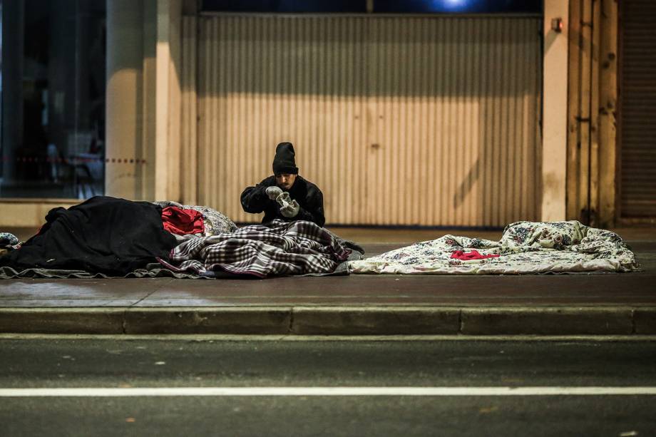 Morador de rua se alimenta com sopa distribuída por voluntários, na região central de São Paulo