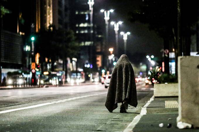 Morador de rua caminha coberto por mantas na Avenida Paulista. Os termômetros chegaram a marcar 7,9º C em São Paulo