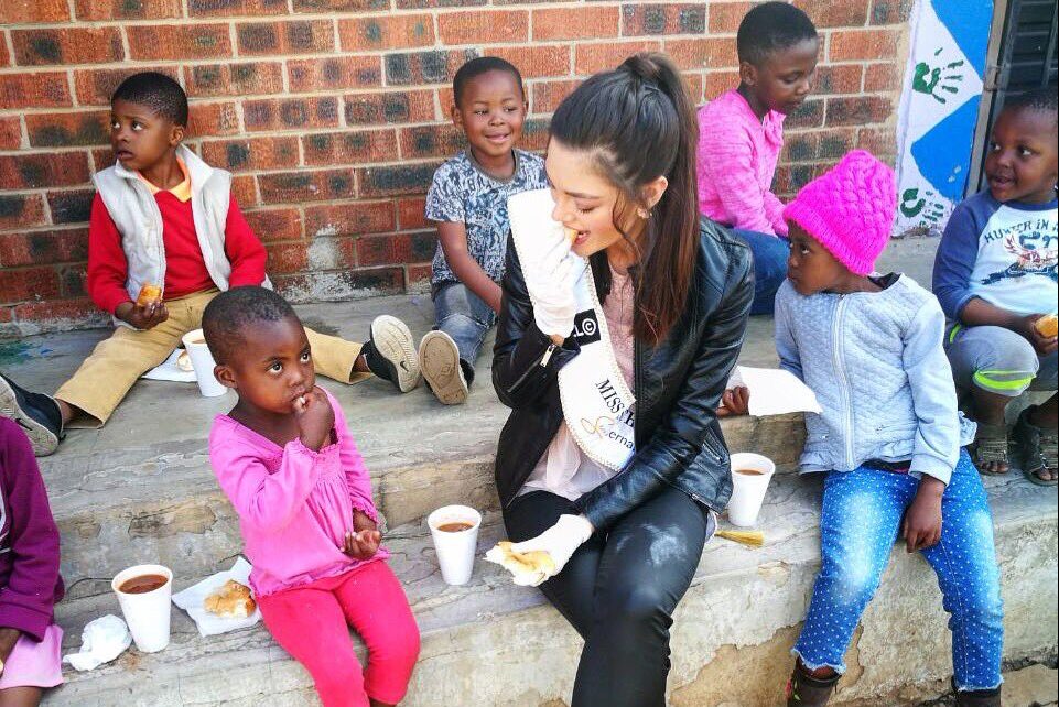 Miss sul-africana Demi-Leigh Nel-Peters em ação em orfanato de Soweto, distrito de Johanesburgo