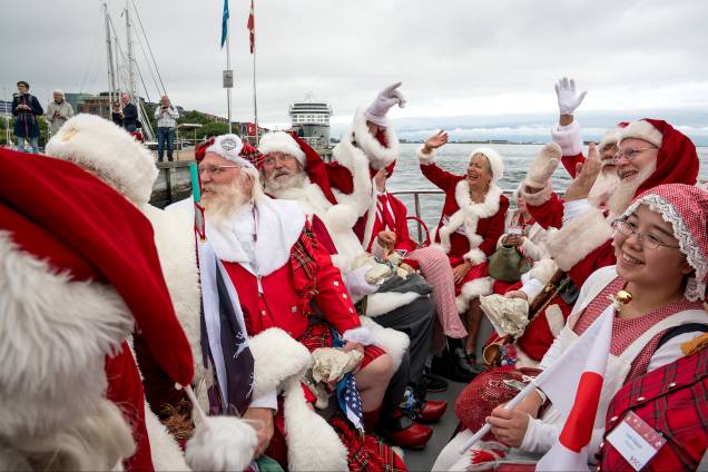 Papais e Mamães Noéis acenam durante a chegada em Copenhague para o primeiro dia do Congresso Mundial de Papais Noéis na Dinamarca Papais e Mamães Noéis acenam durante a chegada em Copenhague para o primeiro dia do Congresso Mundial de Papais Noéis na Dinamarca