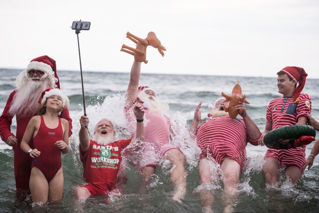 Pessoas vestidas de Papai Noel se banham no mar durante a 60º edição do Congresso Mundial dos Papais Noéis em Copenhague, na Dinamarca