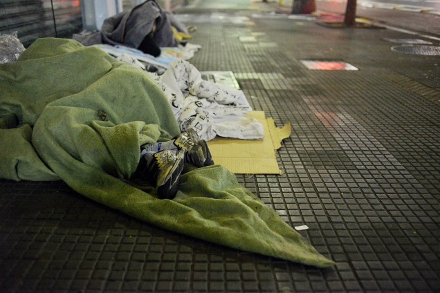 Moradores de rua se aquecem com cobertores para se protegerem do frio. Termômetros chegaram a marcar 7,9ºC, em São Paulo