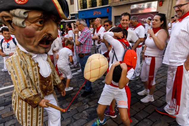 Um "kiliki" persegue e atinge crianças durante um desfile como parte do Festival de São Firmino em Pamplona, na Espanha
