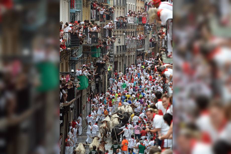 Os touros de combate de Puerto de San Lorenzo perdeguem participantes durante a terceira corrida de touros do festival de São Firmino, em Pamplona, ​​na Espanha