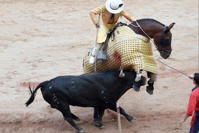 Um touro de luta de Fuente Ymbro se choca com um cavalo enquanto o cavaleiro crava uma lança no animal, durante a quarta corrida de touros do Festival de São Firmino em Pamplona