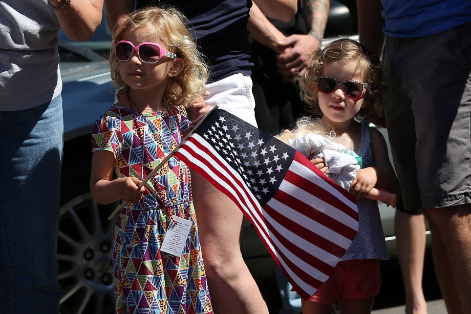 Uma menina segura uma bandeira dos EUA assistindo a uma parada marcando o Dia da Independência em Deer Isle, Maine - 04/07/2017