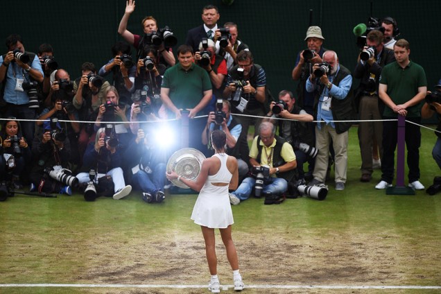 Tenista Garbine Muguruza, da Espanha, posa com o troféu do torneio de Wimbledon, após vencer a americana Venus Williams na final, em Londres