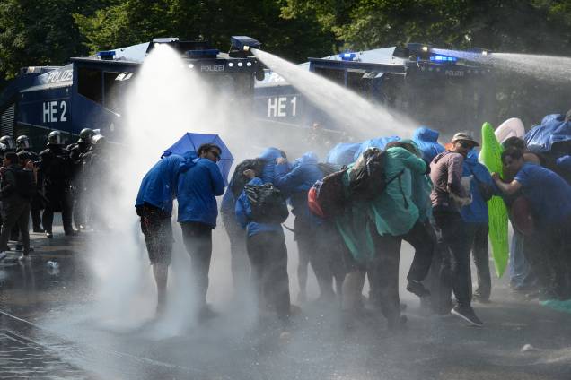 Manifestantes são atingidos por jatos de água de caminhões da policia alemã na tentativa de dispersar os protestos contra a conferência do G20, em Hamburgo.
