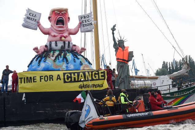 Ativistas do Greenpeace manifestam contra a conferência do G20 ao lado de uma estátua do presidente norte americano Donald Trump.