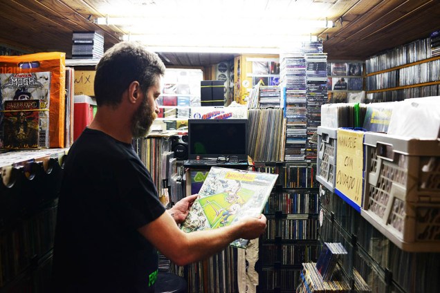 Homem olha um vinil em uma loja de discos na Galeria do Rock