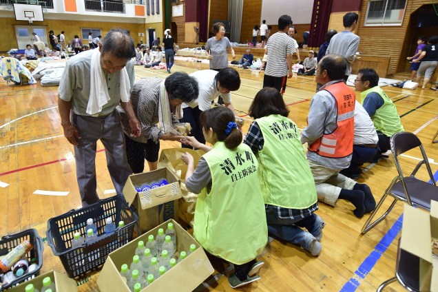 Residentes evacuados de uma área inundada recebem ajuda em uma escola em Hita, prefeitura de Oita. Pelo menos duas pessoas foram mortas e cerca de 20 outras estão desaparecidas em grandes inundações que estão surgindo no sul do Japão.