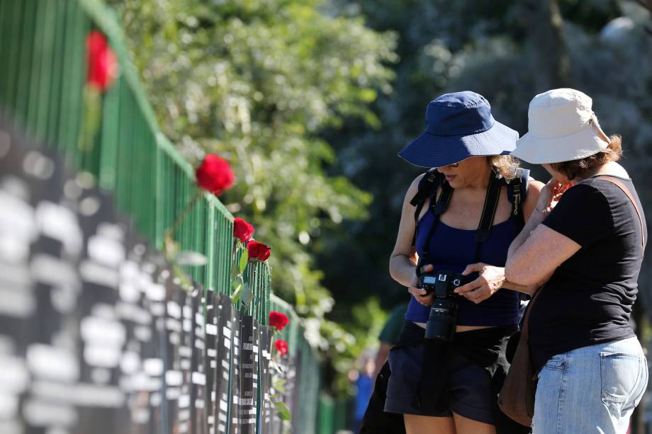 Turistas param para observar a homenagem feita aos 91 policiais mortos em serviço este ano pela ONG Rio de Paz, na Lagoa Rodrigo de Freitas - 25/07/2017