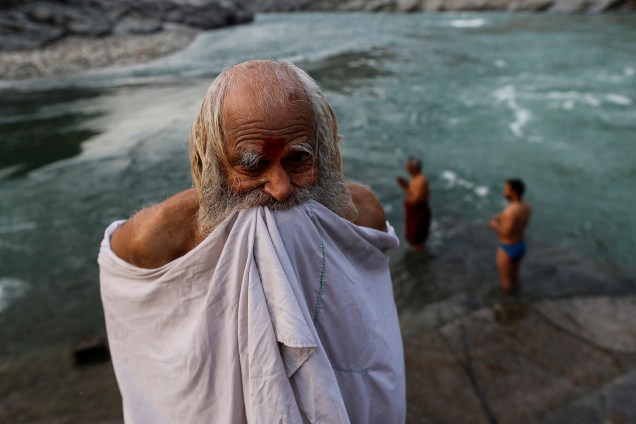 Um devoto hindu se enrola em suas roupas após um mergulho no rio Ganges em Devprayag na índia.