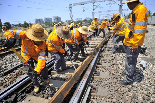 Funcionários trabalham na substituição de peças em linha de trem na cidade de Jinan, China - 14/07/2017