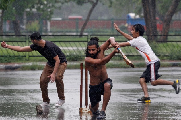 Jovens jogam cricket em um estacionamento durante a chuva em Chandigarh, na Índia - 11/07/2017