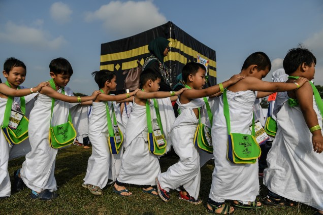 Crianças muçulmanas andam em volta de uma maquete da Caaba, a estrutura sagrada do Islã, localizada na cidade sagrada de Meca, durante uma simulação educativa da peregrinação do Hajj em uma escola em Shah Alam, na Malásia - 24/07/2017