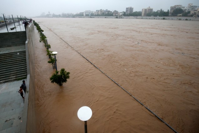 Pessoas observam a inundação do rio Sabarmati após fortes chuvas em Ahmedabad, na Índia - 25/07/2017